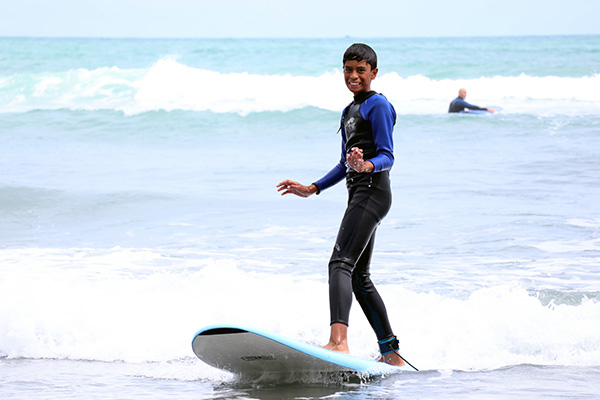 Student Hariki surfing in Raglan
