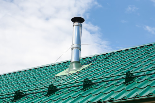 stainless steel metal chimney pipe roof house against sky